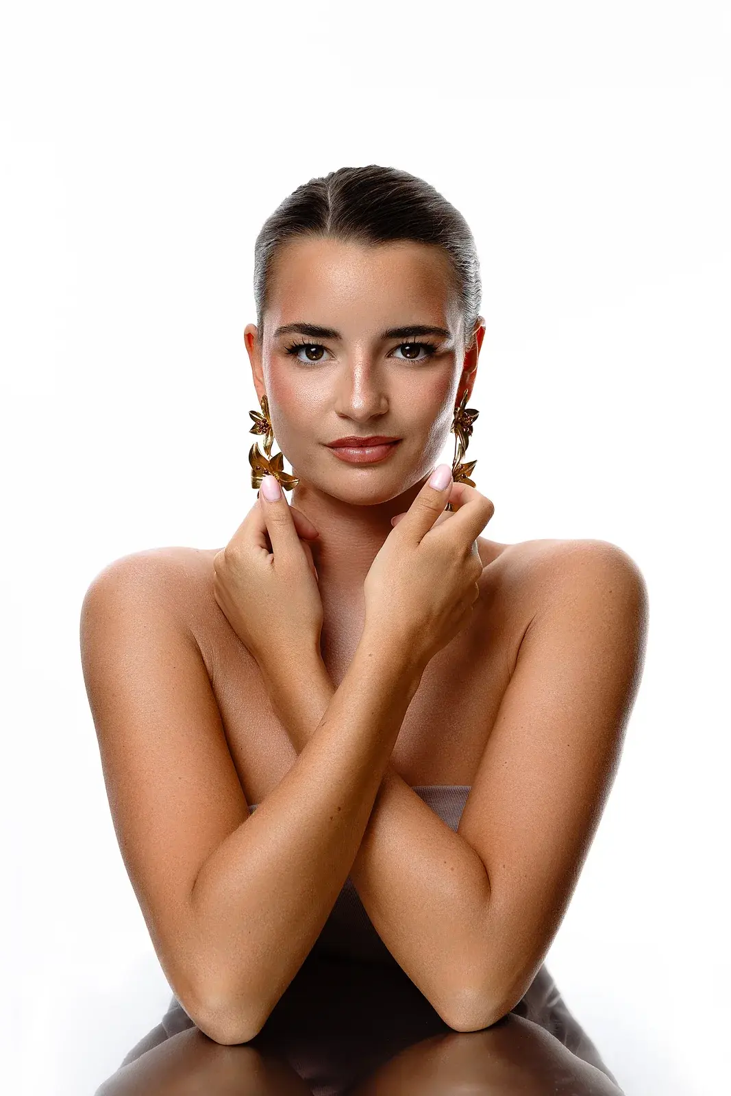 Editorial beauty makeup with a luminous finish and statement gold earrings by Mihaela Taban